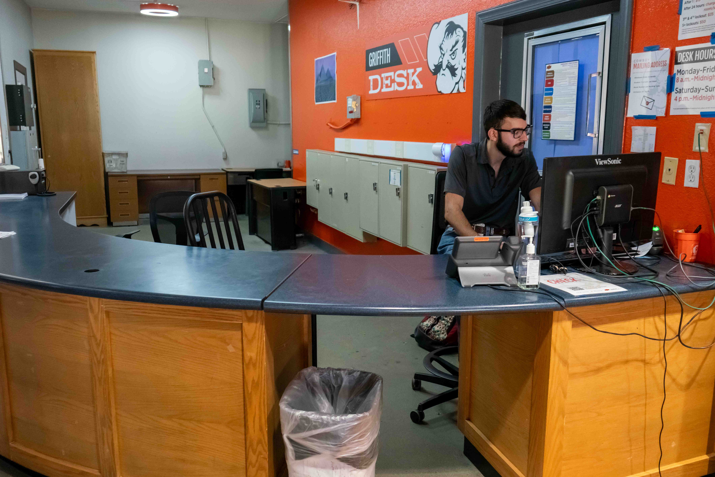 man sitting behind desk working on computer