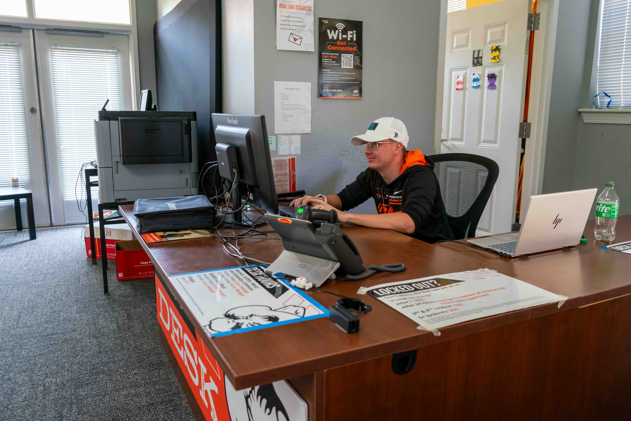 man sitting behind desk working on computer