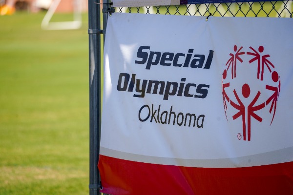 Special Olympics sign on fence.